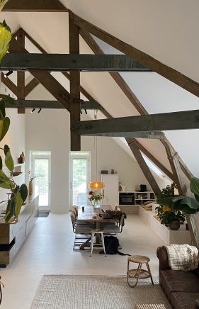 Lichte vloer in VERBAU-betonstuc die naadloos doorloopt in een lounge meubel met trap.